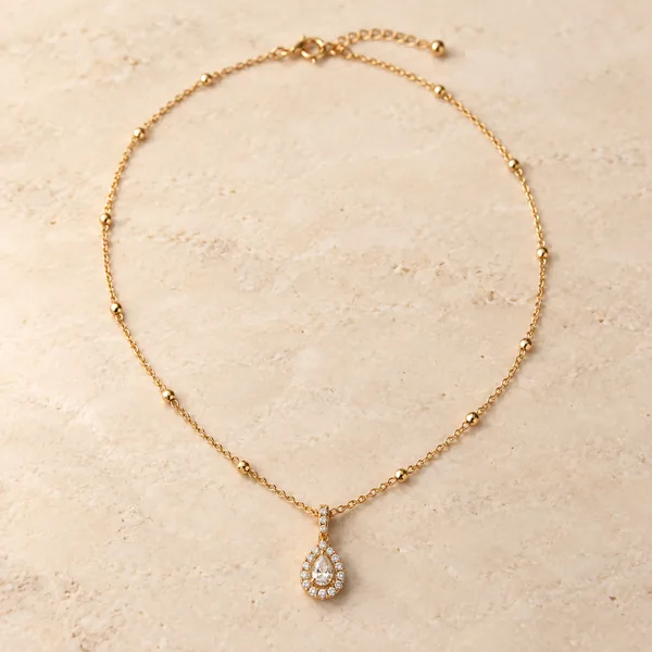 A fine gold chain with a teardrop pendant