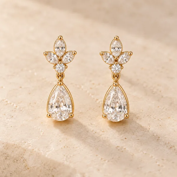 A pair of gold drop earrings with white stones