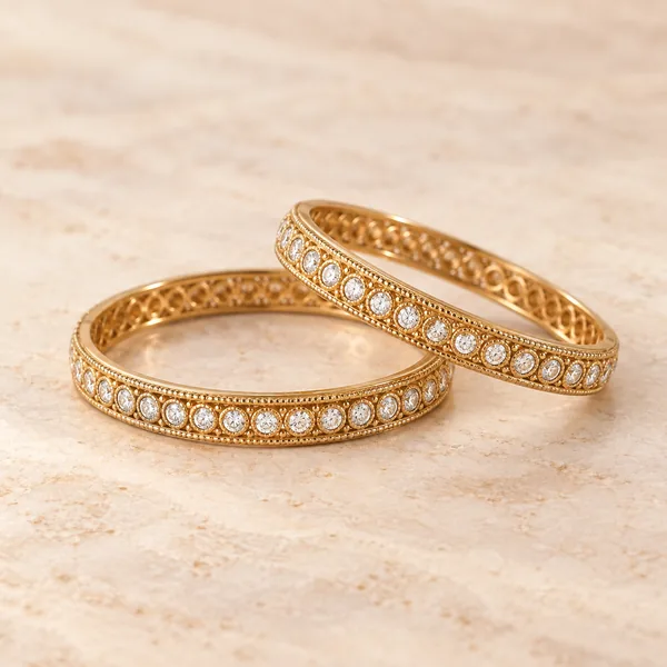 Two gold bangles set with small white stones