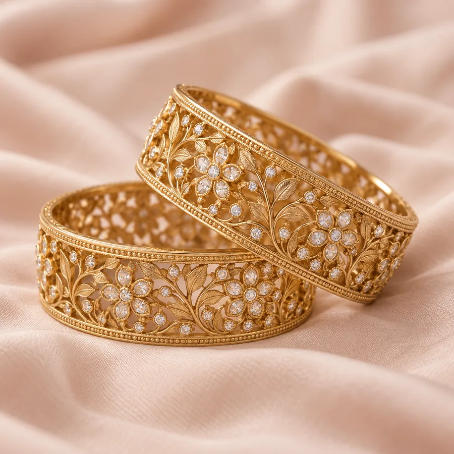 Two wide gold bangles with pierced floral work